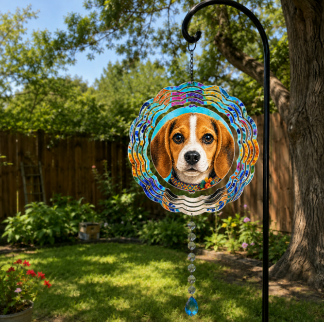 A colorful circular garden suncatcher featuring a printed beagle dog portrait, hanging from a black metal garden stake in a lush backyard garden.
