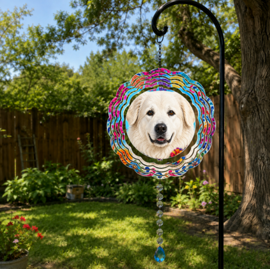 A circular garden suncatcher with a colorful wavy border and a portrait of a white dog in the center, hanging from a black metal pole in a sunny backyard garden.