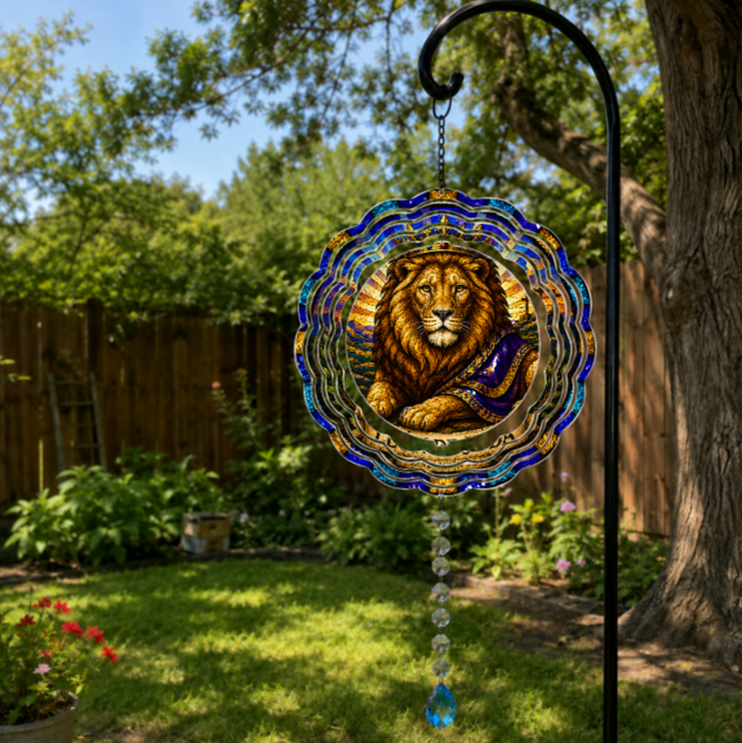 A circular stained-glass garden hanging ornament featuring a detailed regal lion portrait, suspended from a black metal garden stake in a sunny backyard garden.